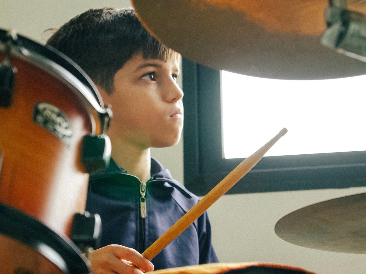 Aluno tocando bateria na Musicalização Agrícola