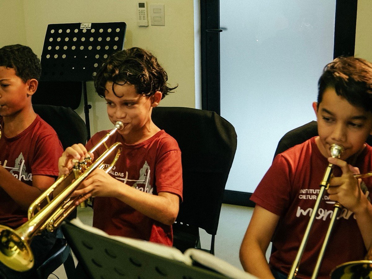 Crianças do Instituto Cultural das Montanhas tocando trompete e trombone