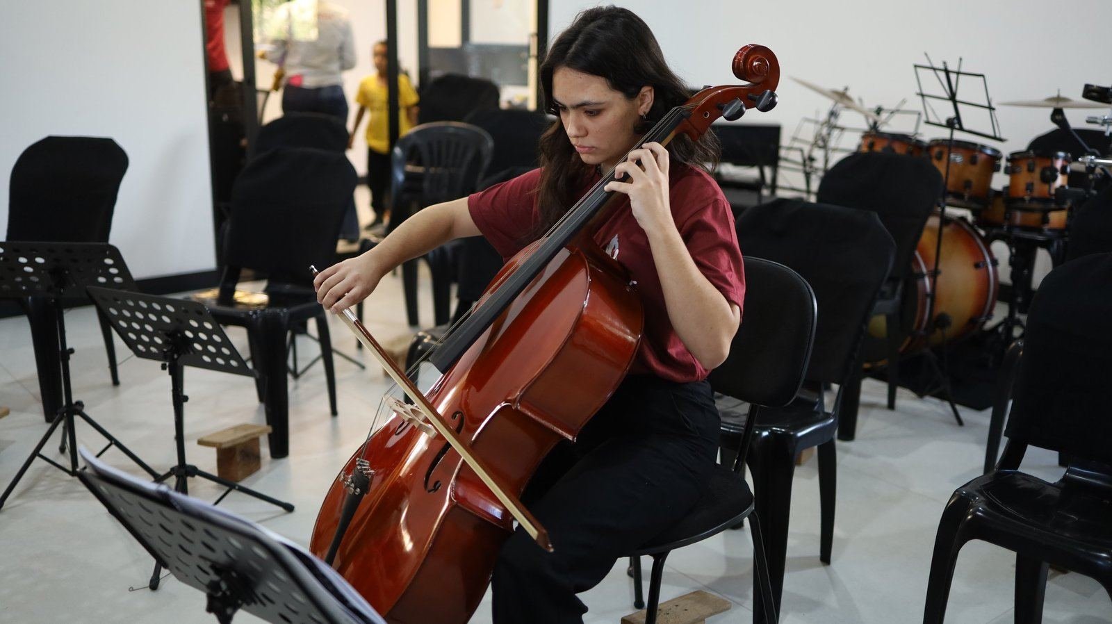 Aluna tocando violoncelo em ensaio da Orquestra Jônice Tristão