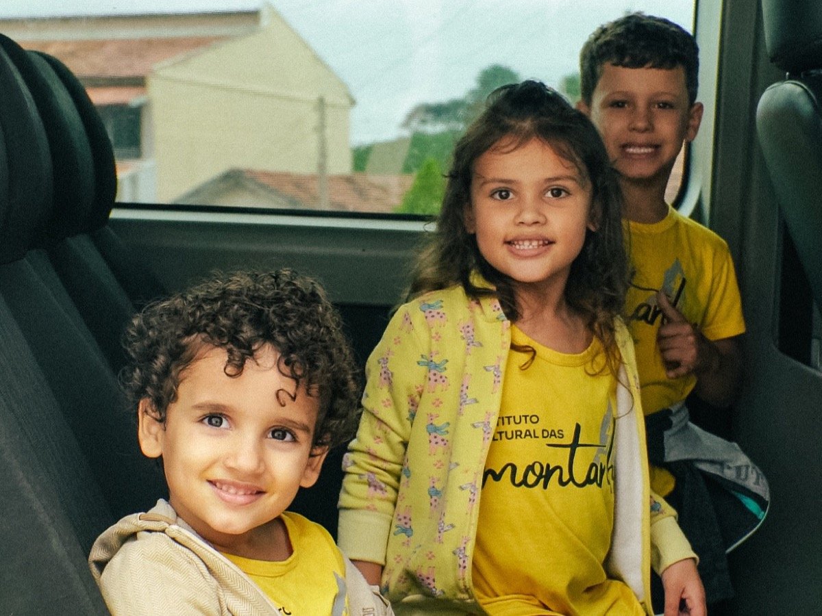 Crianças do Instituto Cultural das Montanhas sorrindo, uniformizadas